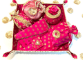 A collection of bridal trousseau gift set including metal boxes, bangles, and other wedding accessories, predominantly in pink and adorned with decorative elements.