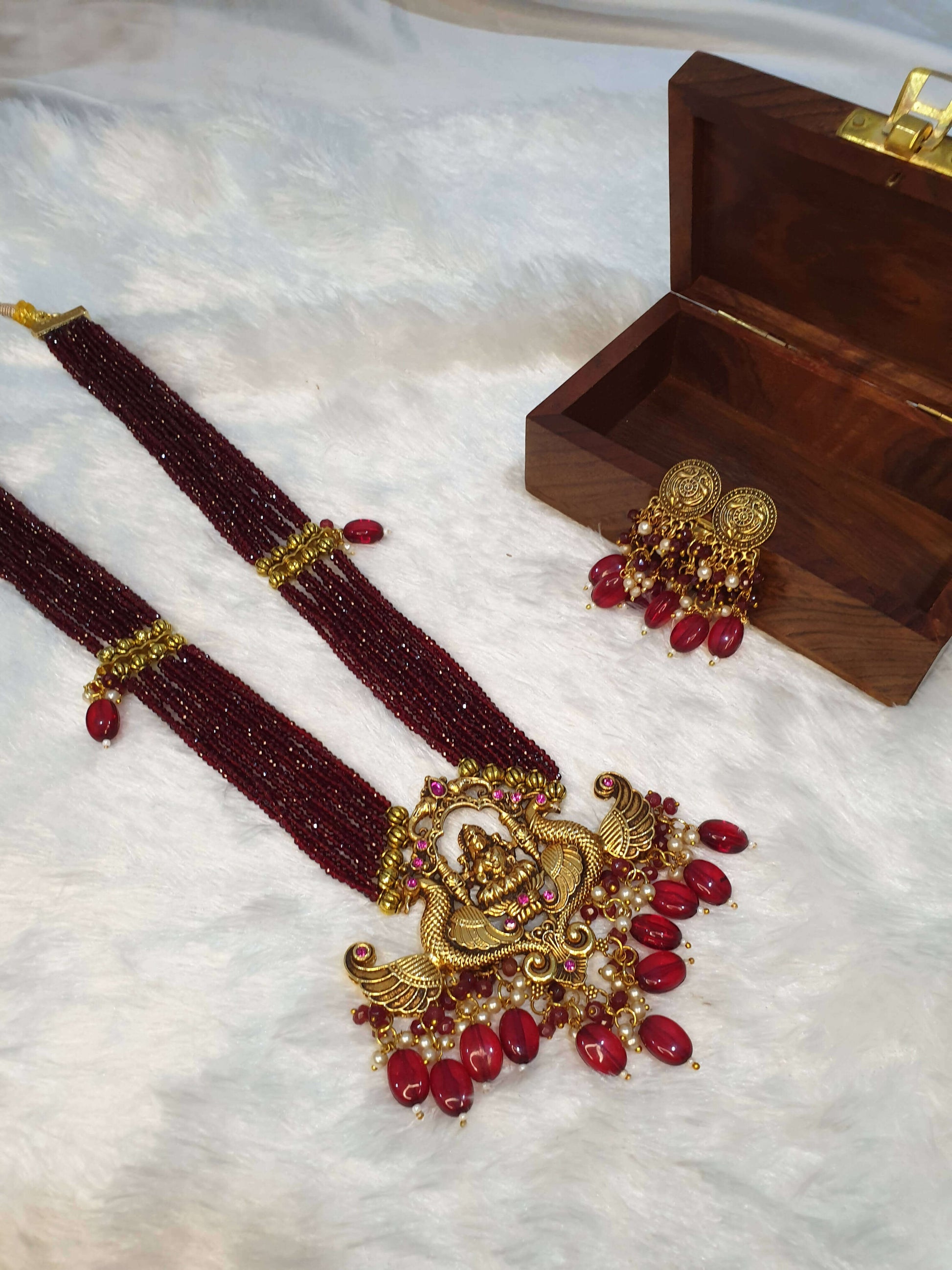 multi-layered maroon Laxmi pendant necklace with earrings in the wooden jewellery box