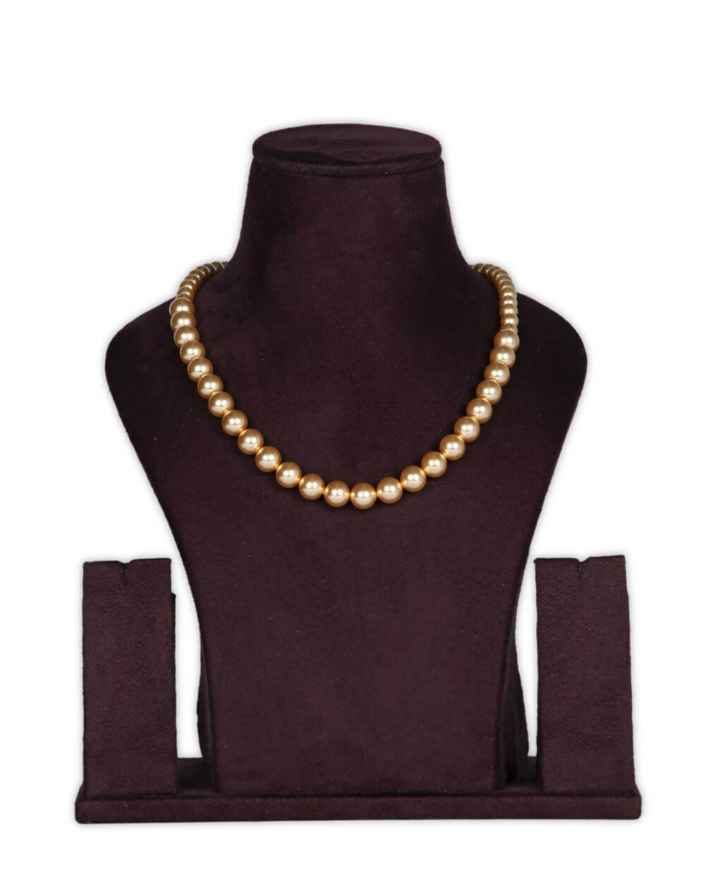 A gold-colored necklace featuring a string of pearls displayed on a mannequin bust.