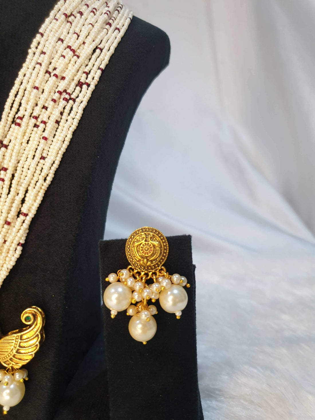A display of traditional Indian jewelry, featuring earrings with gold accents and pearls.