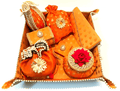 A collection of bridal trousseau gift set including metal boxes, bangles, and other wedding accessories, predominantly in orange and adorned with decorative elements.