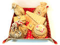 A collection of bridal trousseau gift set including metal boxes, bangles, and other wedding accessories, predominantly in skin color and adorned with decorative elements.