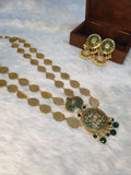 A gold-colored double layered filigree petals necklace accompanied by matching earrings, displayed on a white surface with a wooden box in the background.