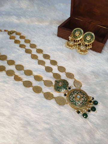 A gold-colored double layered filigree petals necklace accompanied by matching earrings, displayed on a white surface with a wooden box in the background.