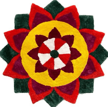 A vibrant, colorful Special Rangoli Mats design is shown against a white background. The intricate circular pattern is made of red, dark red, green, and yellow colored materials, arranged in the shape of a flower with multiple layers of petals.