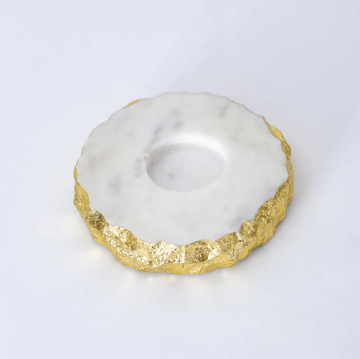 A round marble tea light holder with gold foil accents on a white background.