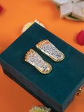 A pair of gold and silver-plated Laxmi Charan Paduka, which are symbolic footprints of the Hindu goddess Lakshmi, placed on a dark green velvet box