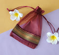 Pink design Organza Potli Bags with flowers around it