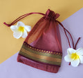 Red design Organza Potli Bags with White flowers around it