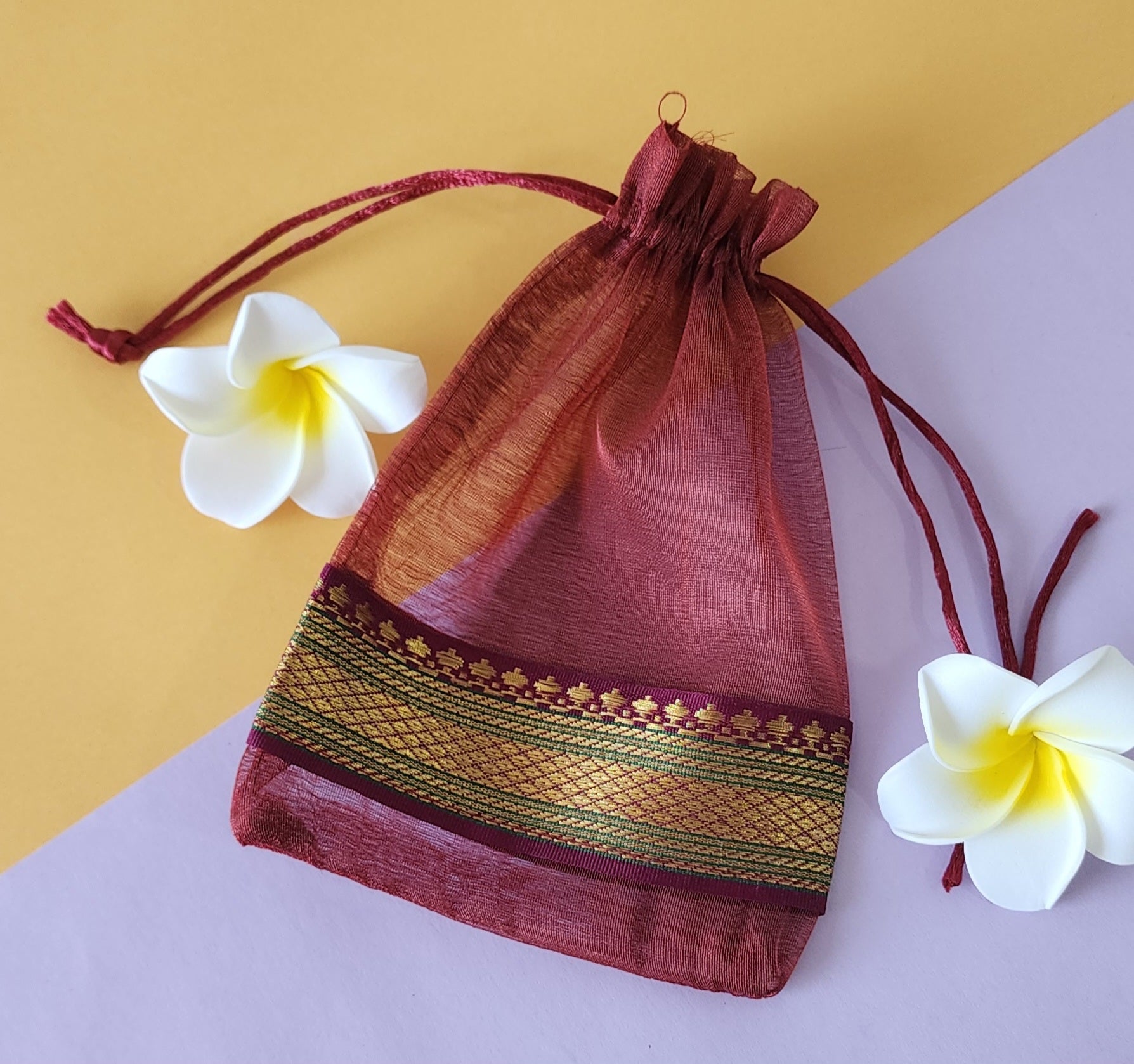 Red design Organza Potli Bags with White flowers around it