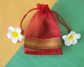 Red design Organza Potli Bags with flowers around it