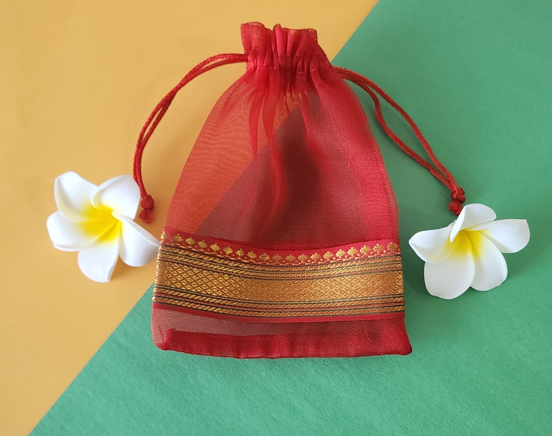 Red design Organza Potli Bags with flowers around it