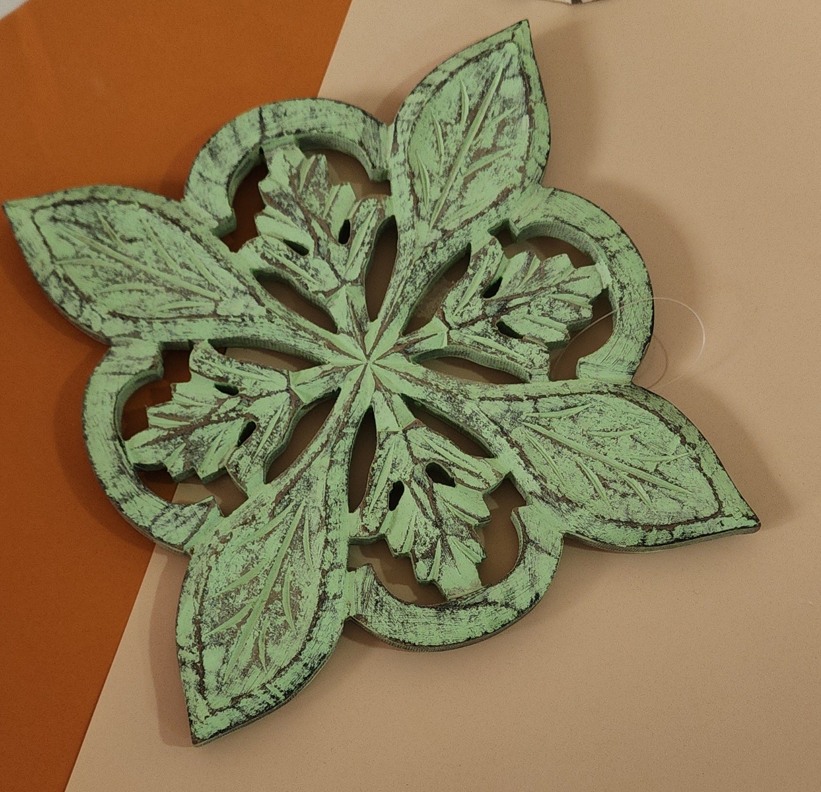 Wooden Carved Trivet in a sleek green finish at floor
