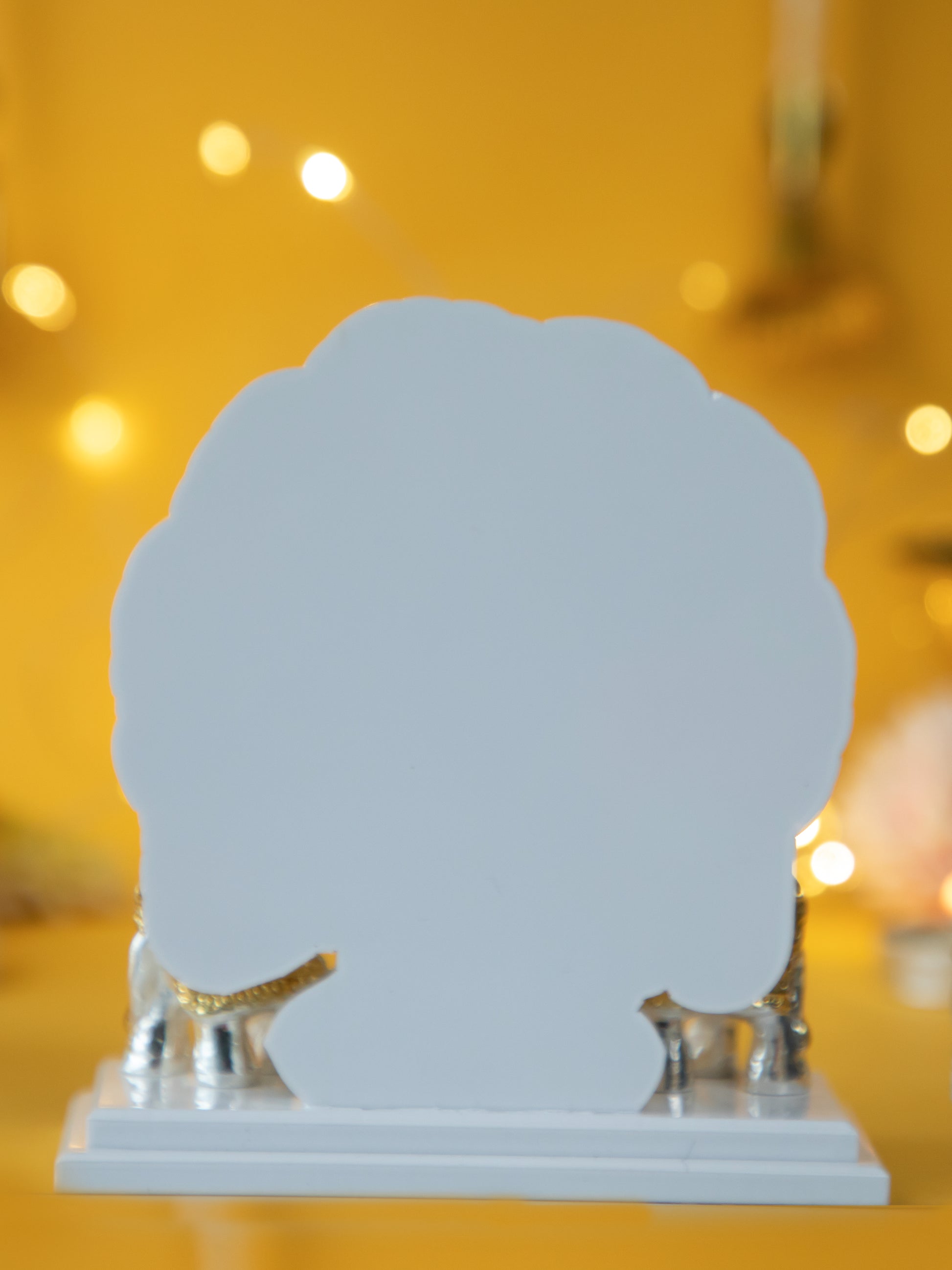 Decorative shell-shaped object of lord ganesha idol on a stand with a warm, blurred background