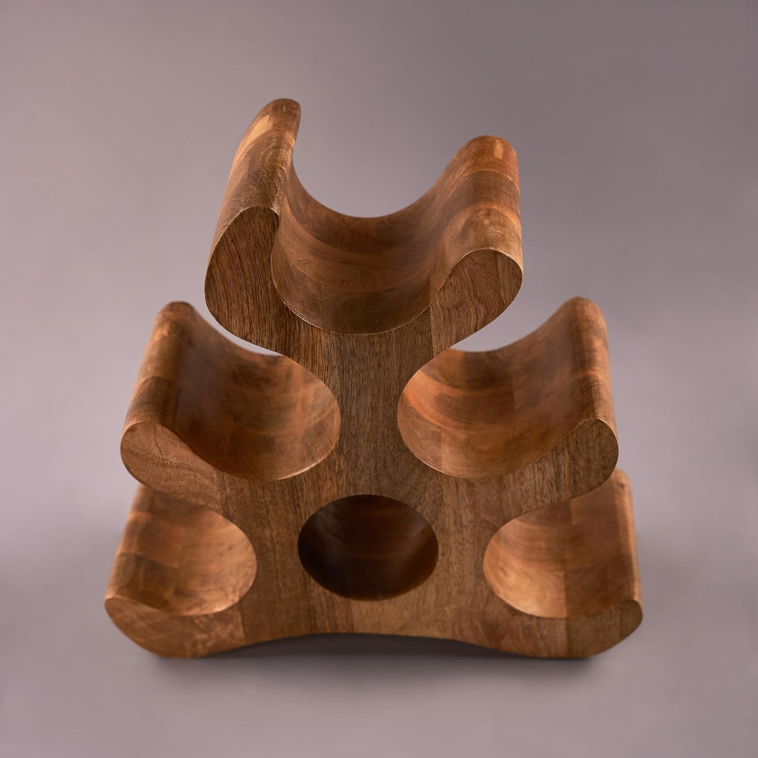 A wooden carved wine bottle holder with intricate carvings, designed to store wine bottles.