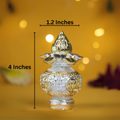 A small silver kalash with a gold-colored coconut on top. The kalash is decorated with silver and gold accents and has a height of 4 inches and a width of 1.2 inches.
