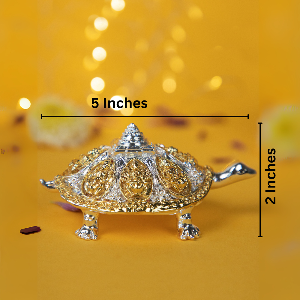 An image of a decorative turtle idol, featuring golden and silver metallic finishes. The turtle's shell is adorned with carvings of what appear to be Hindu goddesses. Text overlays on the image indicate the object's dimensions: 5 inches in length and 2 inches in height. The description includes the phrase "turtle for vastu pooja."
