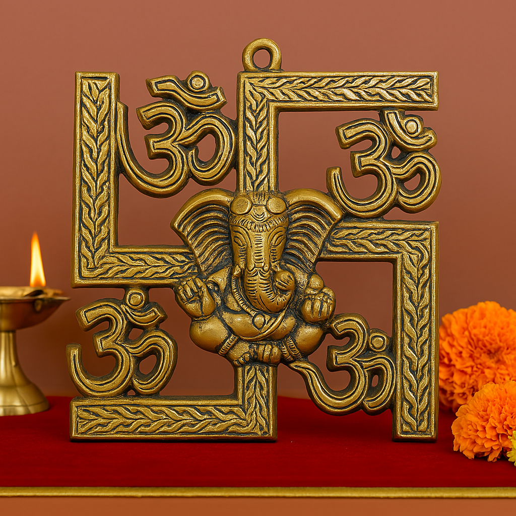 Brass-finished decorative swastika wall hanging with embossed Om symbols and a central Lord Ganesha figure, placed against a warm background with a brass oil lamp and marigold flowers.